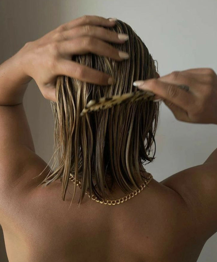 Model combing through short, wet hair 