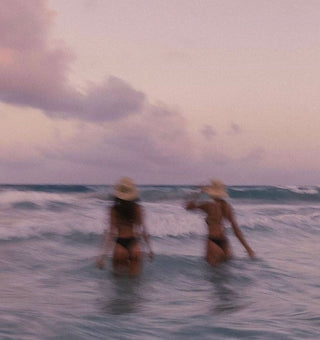 Two women walking into the water, blurry