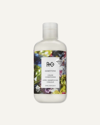 R+Co gemstone color conditioner bottle, featuring a sleek design, used for nourishing and enhancing vibrant hair color.