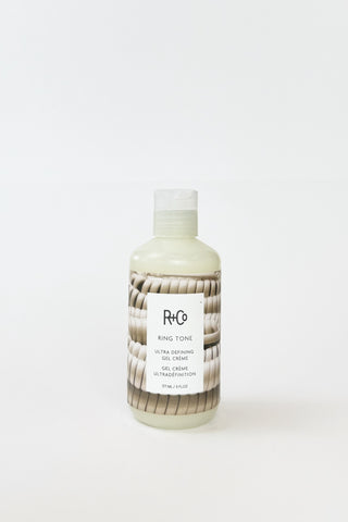 R+Co Ring Tone Ultra Defining Curl Gel Creme applied to curly hair, showcasing its smooth, defined curls and shiny finish.
