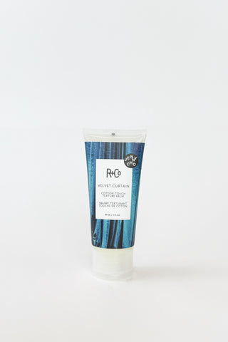 R+Co Velvet Curtain Texture Balm hair balm in a jar, showcasing smooth, velvety texture for styling and texture enhancement.