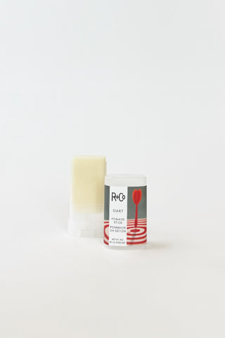 R+Co Dart Pomade Stick for hair styling, featuring a sleek black container with the pomade stick visible.